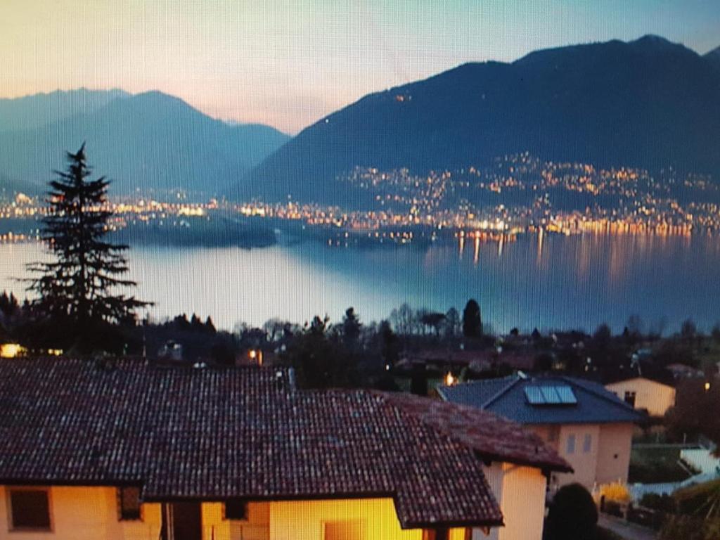 vista para uma cidade e um lago à noite em Viaggi del Lea vista Lago Maggiore em Piazzogna