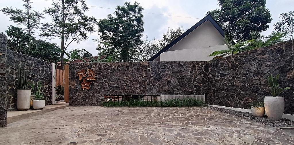 a stone wall with a fireplace in front of a house at Casa Benna - Salatiga in Salatiga