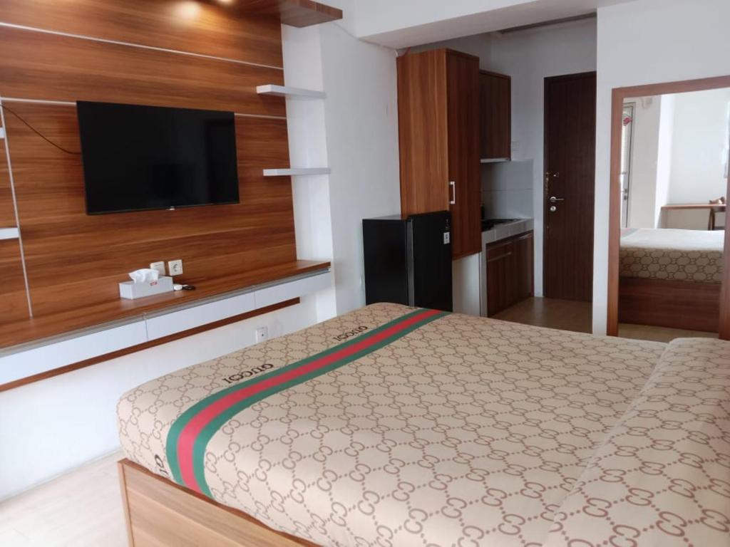 a bedroom with a bed and a flat screen tv at Sansan Room - Apartemen Gunung Putri Square in Parungdengdek