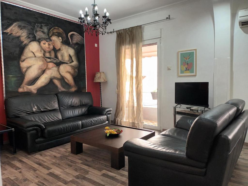 Stunning apartment in the heart of Athens في أثينا: غرفة معيشة بها أريكة و لوحة