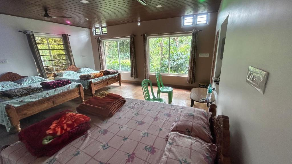 a bedroom with two beds and a room with windows at Homestay In Coorg Doddakallu Betta in Somvārpet