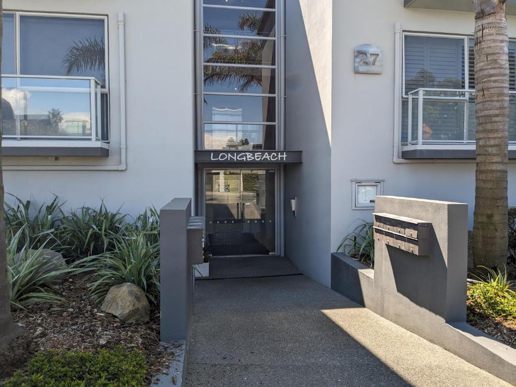 a front door of a building with a sign on it at The Coastal Getaway in Mount Maunganui