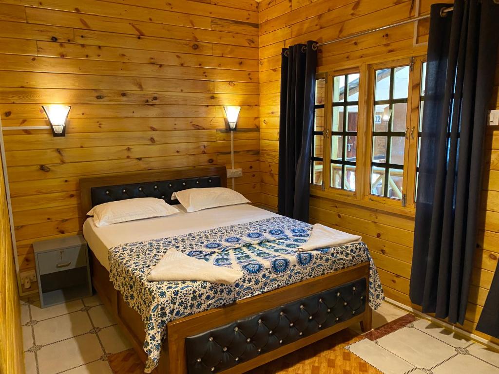 a bedroom with a bed in a wooden room at Chill Out Jasmine Restaurant Bar Rooms in Palolem