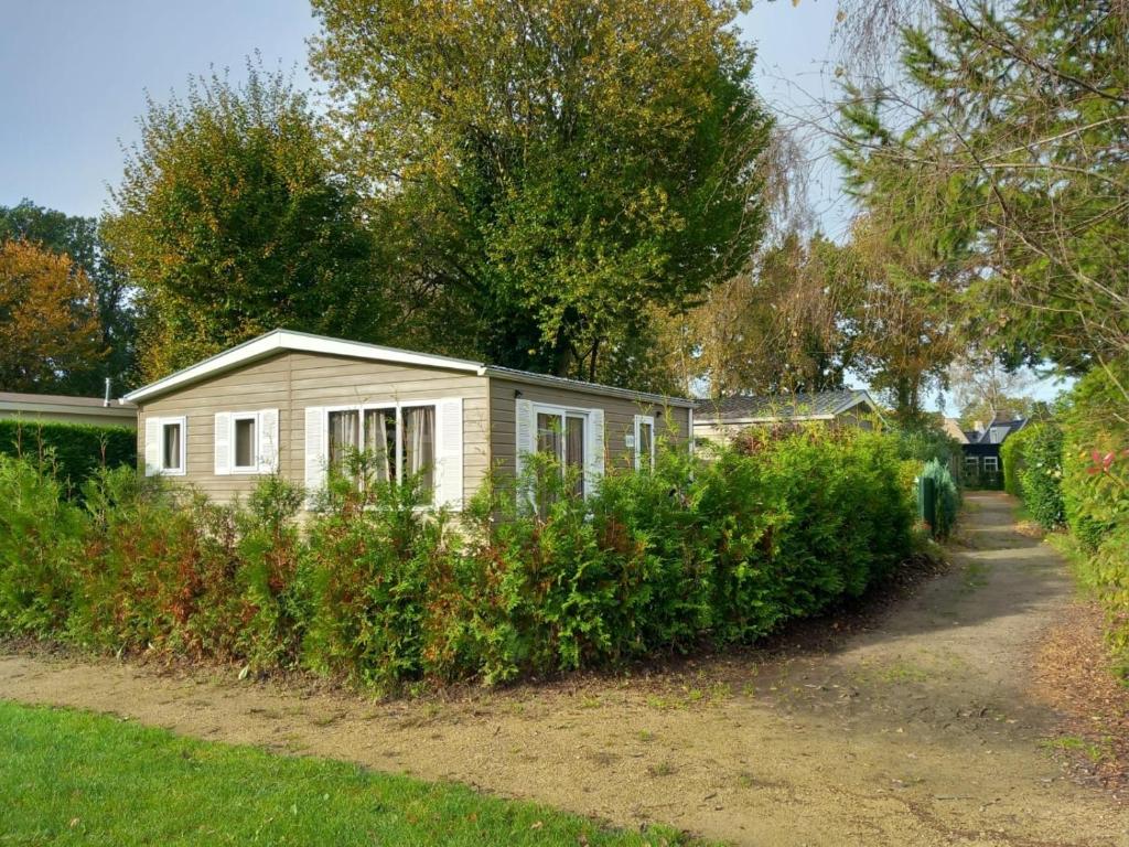 una pequeña casa blanca en medio de un patio en Lodge Damian op de Veluwe, en Voorthuizen