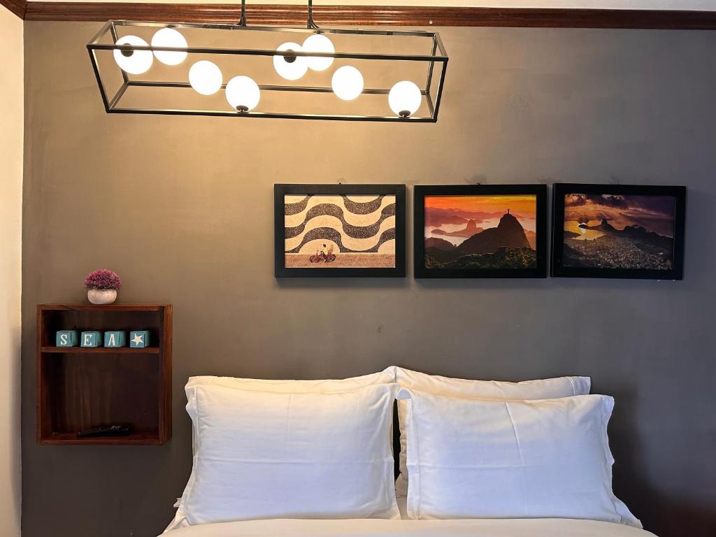 a bedroom with a bed with three pictures on the wall at Brazilian Art & Free Parking - emitimos factura in Quetzaltenango