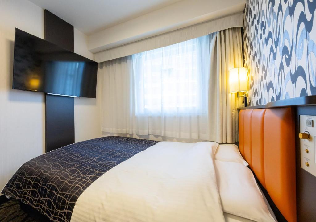 Postel nebo postele na pokoji v ubytování APA Hotel Osaka Umeda