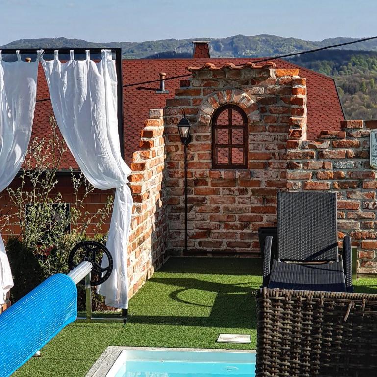 podwórko z ceglaną ścianą i basenem w obiekcie Amazing Milk and Honey cottage with hill views w mieście Novi Marof