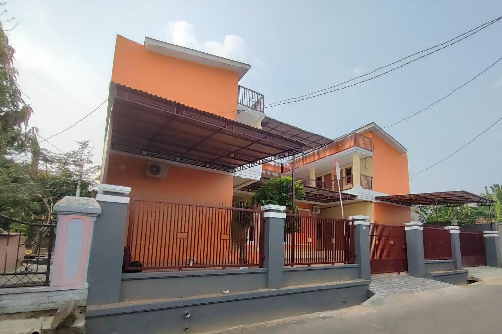 a house with an iron gate and a fence at SPOT ON 93350 Alnasya Syariah in Palembang
