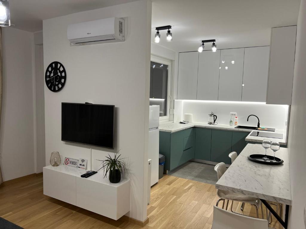 a white kitchen with a tv on a wall at Apartman EMA in Banja Luka