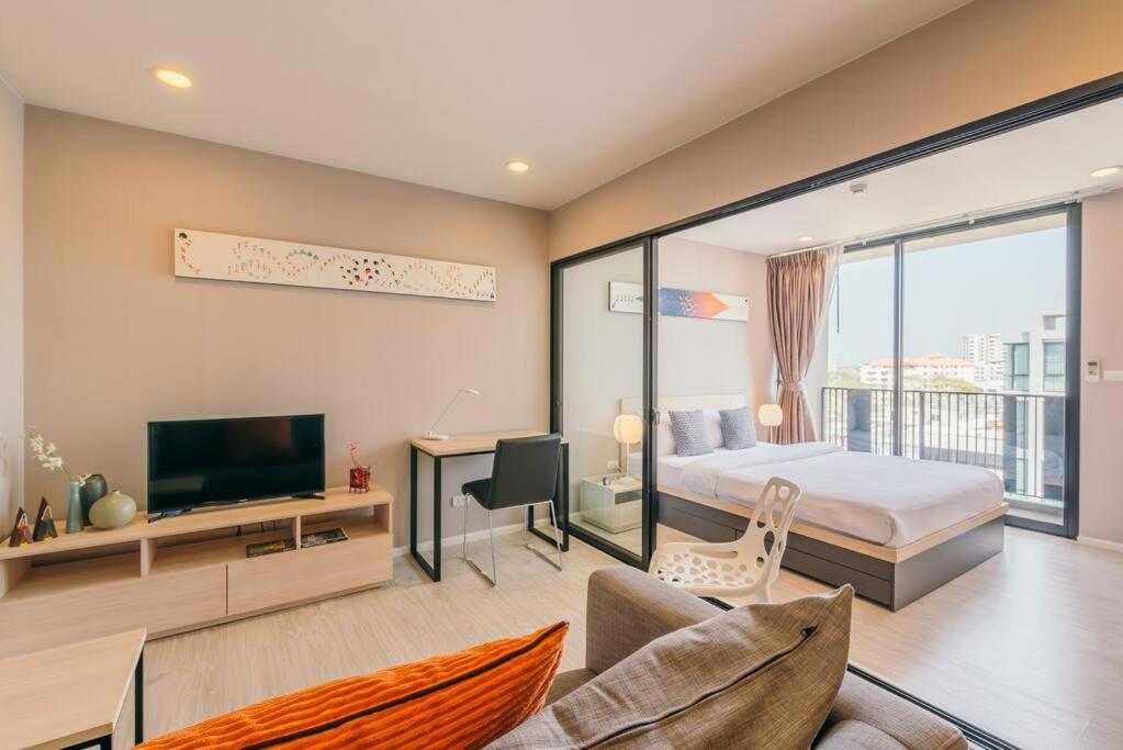 a bedroom with a bed and a tv and a desk at Modern Condo in Nimman (F806) by Pimolplace in Chiang Mai