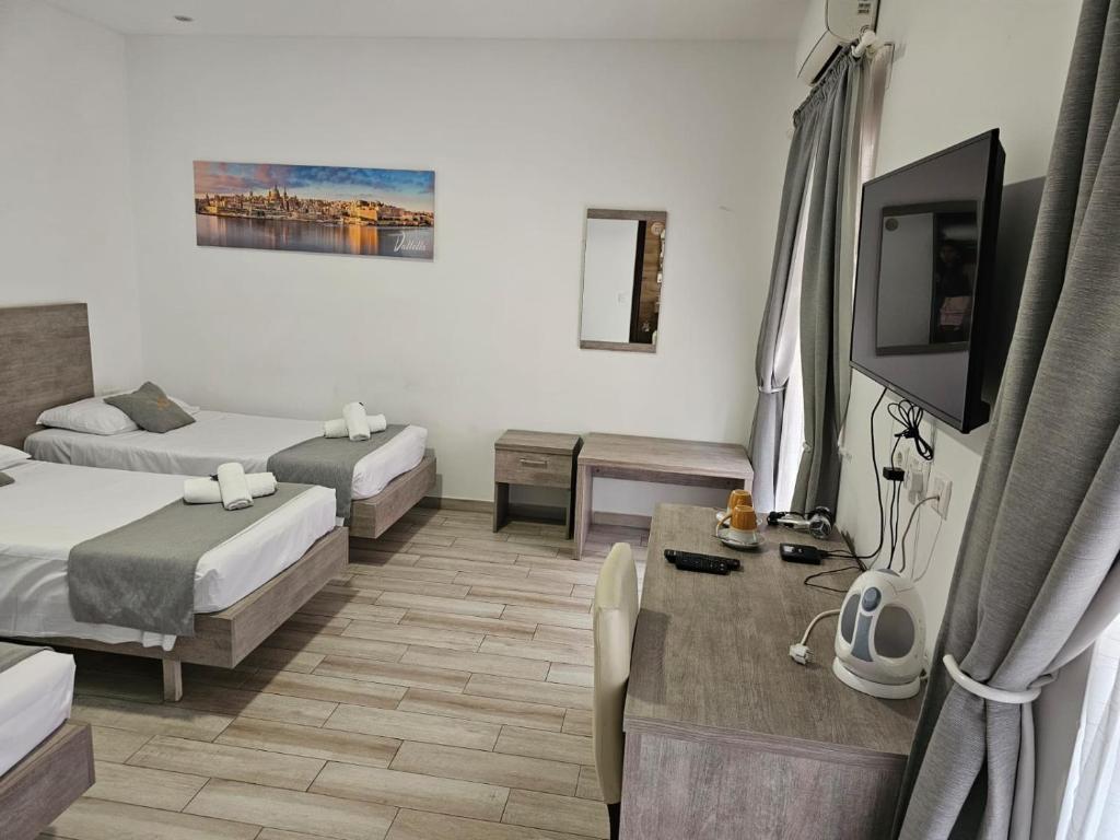 Habitación de hotel con 2 camas y TV en Napoli Suites, en San Julián