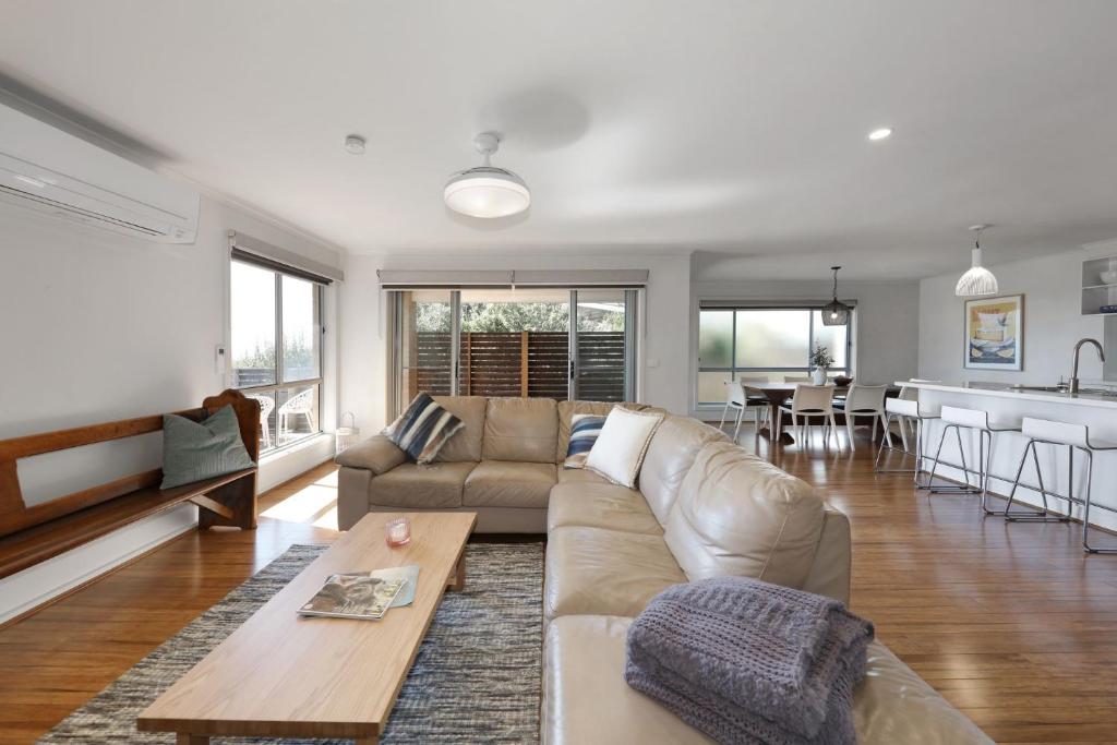 a living room with a couch and a table at Bayview Bliss in Surf Beach