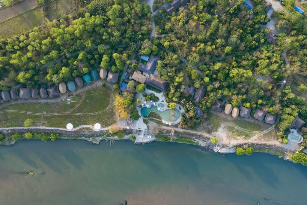 an aerial view of a house next to a lake at Barahi Jungle Lodge in Meghauli