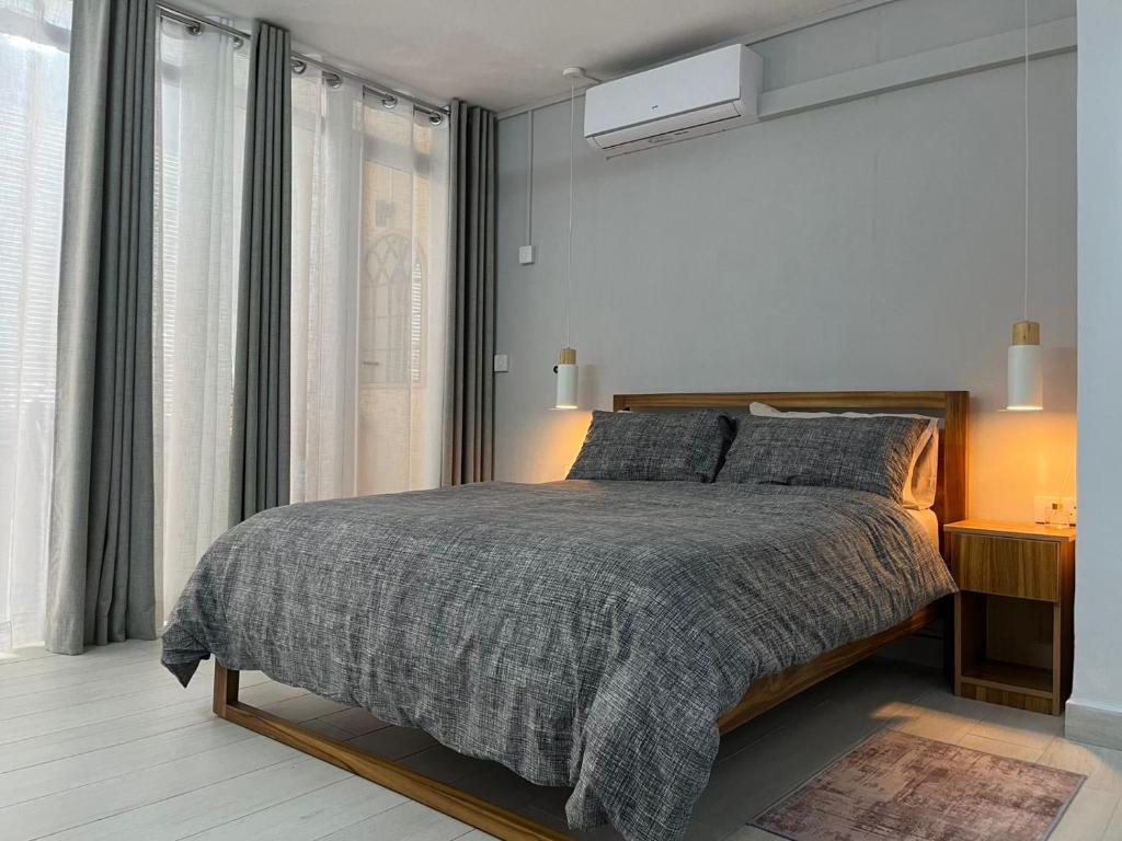 a bedroom with a bed and a large window at Ebrahim Flats - Grand Baie Beach in Grand Baie