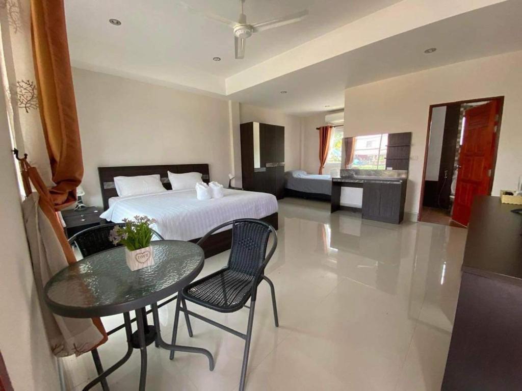 a bedroom with a bed and a table and chairs at Pakham Gardens Resort in Prakham
