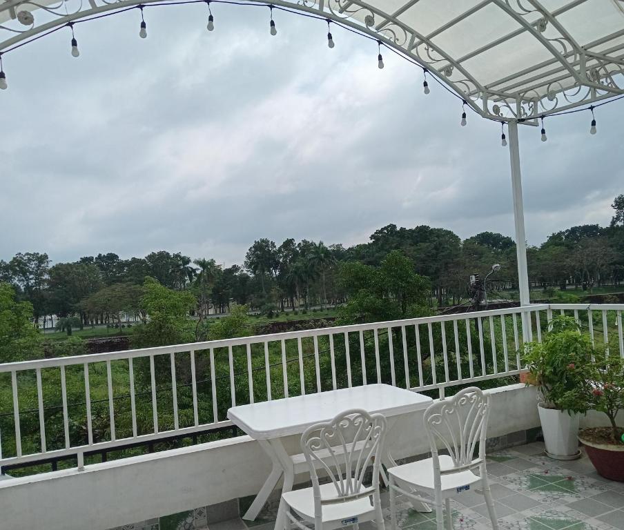 d'une table et de chaises blanches sur un balcon. dans l'établissement Huế Thơ Homestay, à Hue