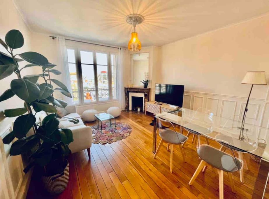 a living room with a table and a potted plant at Appartement neuf, au calme, proche métro in Boulogne-Billancourt