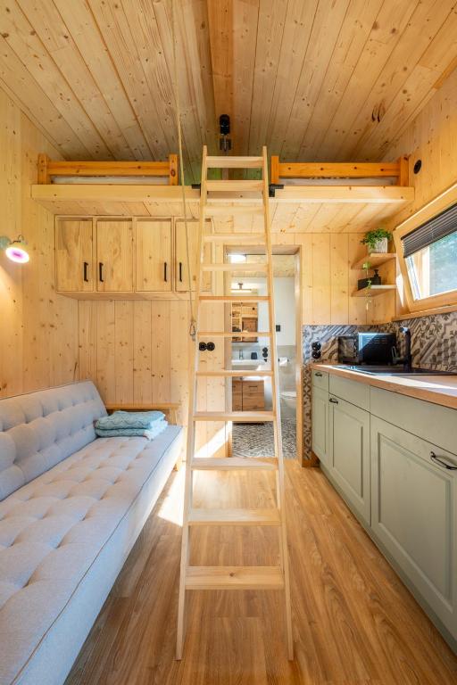 a loft bed in a tiny house with a kitchen at Gloans Glück Ferienhaus in Frasdorf