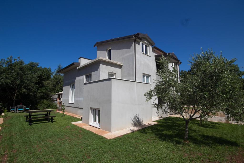 a large white building with a tree in front of it at Apartments Banek in Novigrad Istria