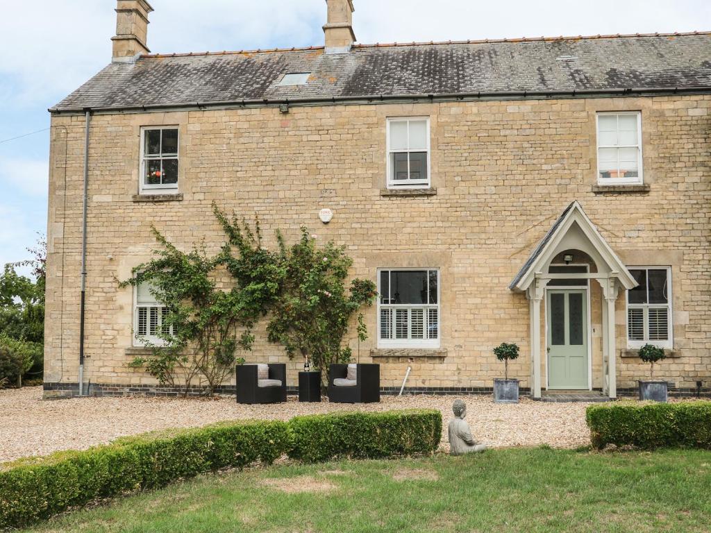 a brick house with a person sitting in front of it at The Coach House in Grantham