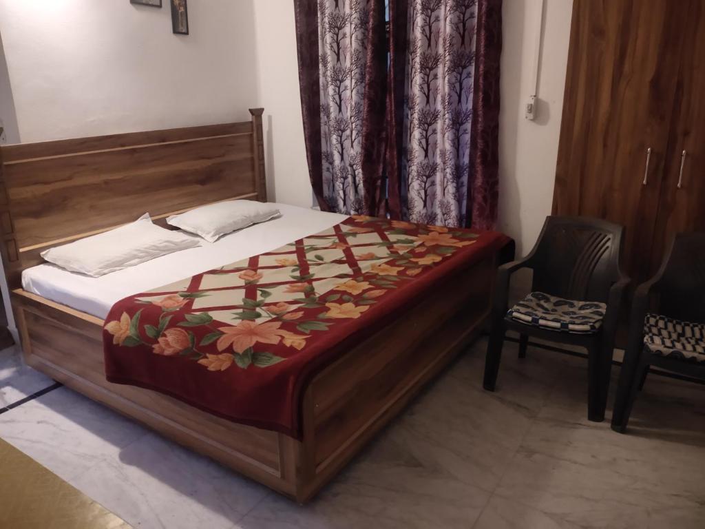 a bedroom with a bed and a chair in a room at Govind Home Stay in Rishīkesh