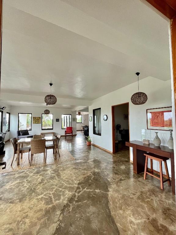 ein großes Wohnzimmer mit einem Tisch und Stühlen in der Unterkunft Casa Giuseppe Bohol 3 in Panglao