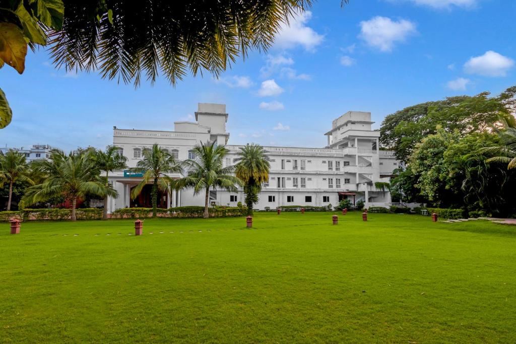 a large white building with a park in front of it at Palette - Hotel Bon Sejour in Puducherry