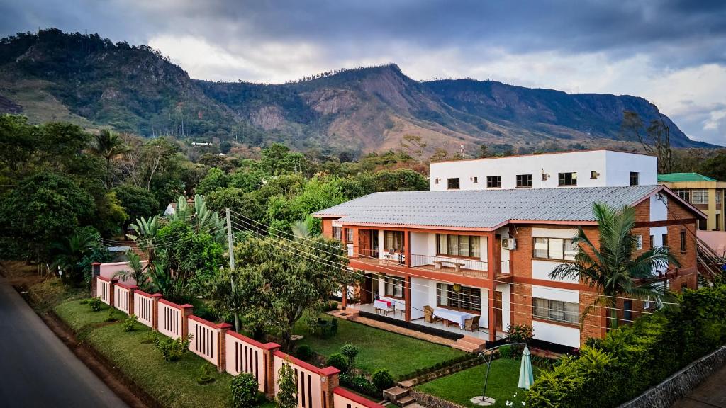 an aerial view of a house with mountains in the background at Mango Lodge Zomba in Zomba