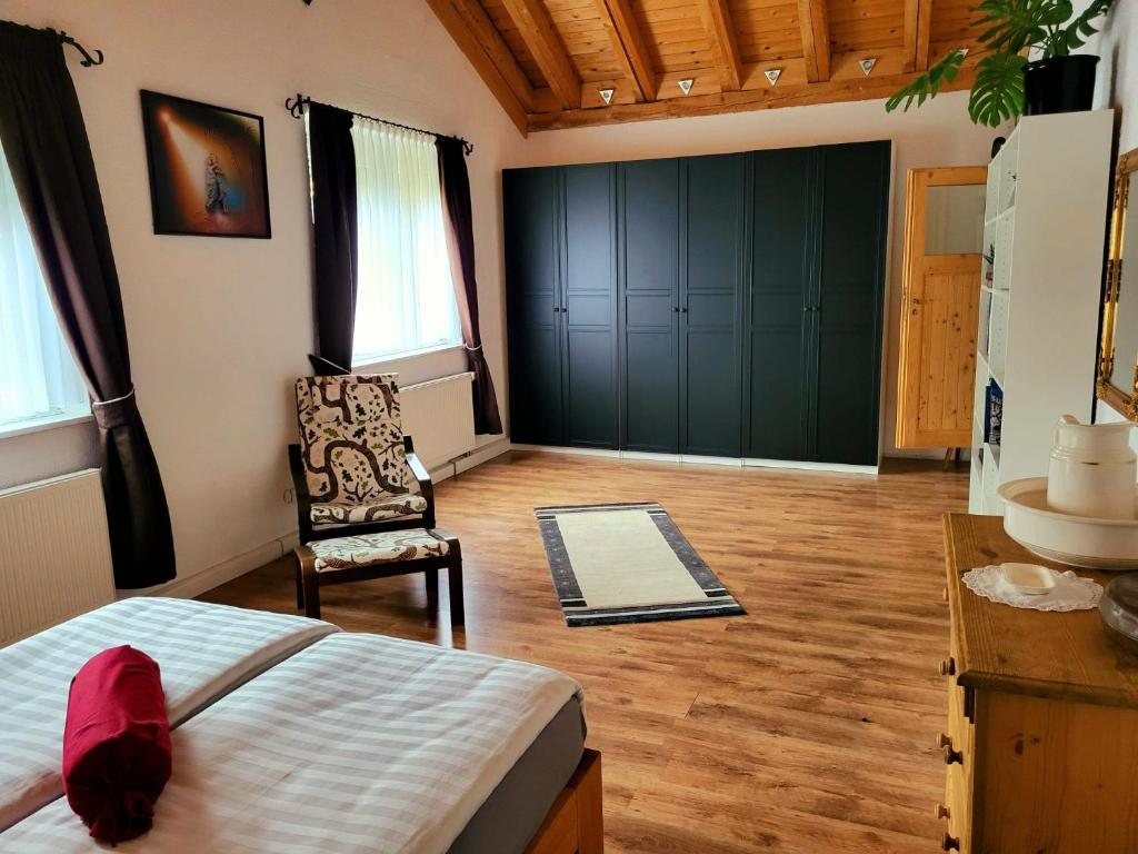 1 dormitorio con 1 cama y 1 silla en una habitación en Haus Röte en Müllheim