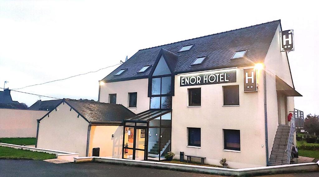 um grande edifício branco com um cartaz em ENOR Hôtel em Guingamp