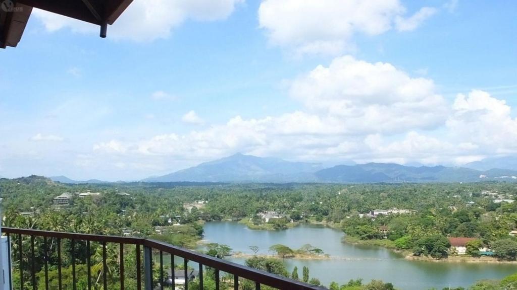 uma varanda com vista para o rio em Villa Arunalu Kandy em Kandy