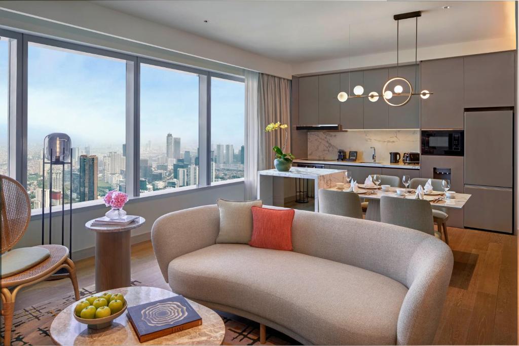 a living room with a couch and a kitchen at PARKROYAL Serviced Suites Jakarta in Jakarta