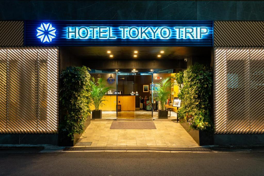 a hotel lobby entrance with a blue sign on it at Hotel Tokyo Trip Ueno Nishi Nippori in Tokyo