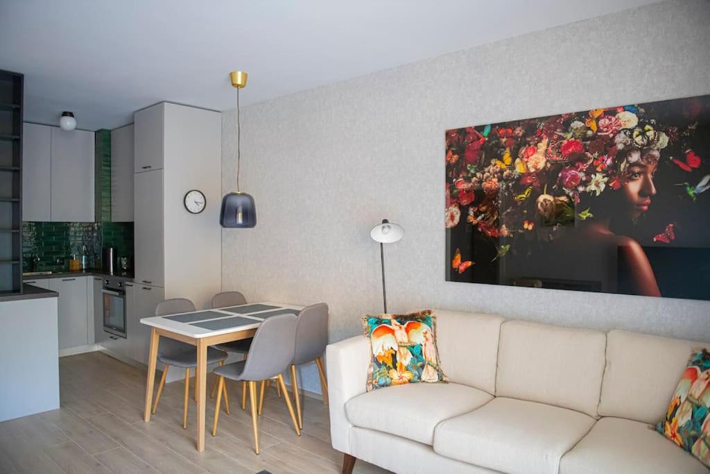 a living room with a white couch and a table at Oslo: A modern furnished apartment with parking in Sofia