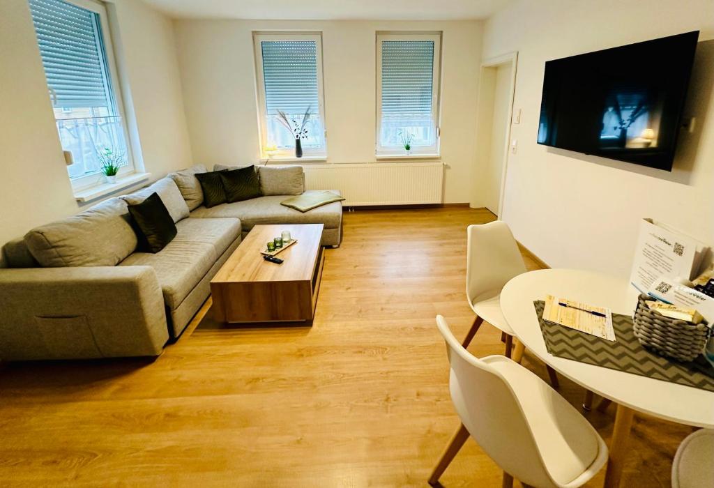 ein Wohnzimmer mit einem Sofa und einem Tisch in der Unterkunft FeWo Buche mit Balkon in Bad Harzburg