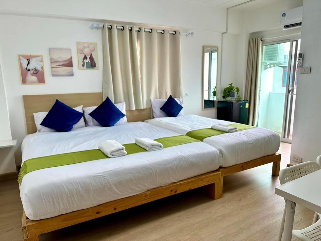 a bedroom with a large bed with blue pillows at 54place​สะพานใหม่ดอนเมือง in Ban Don Muang (1)