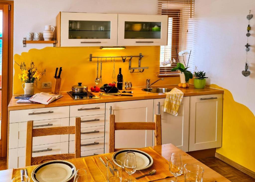 eine Küche mit einem Tisch und einer gelben Wand in der Unterkunft Residence Zirmer in Kastelruth