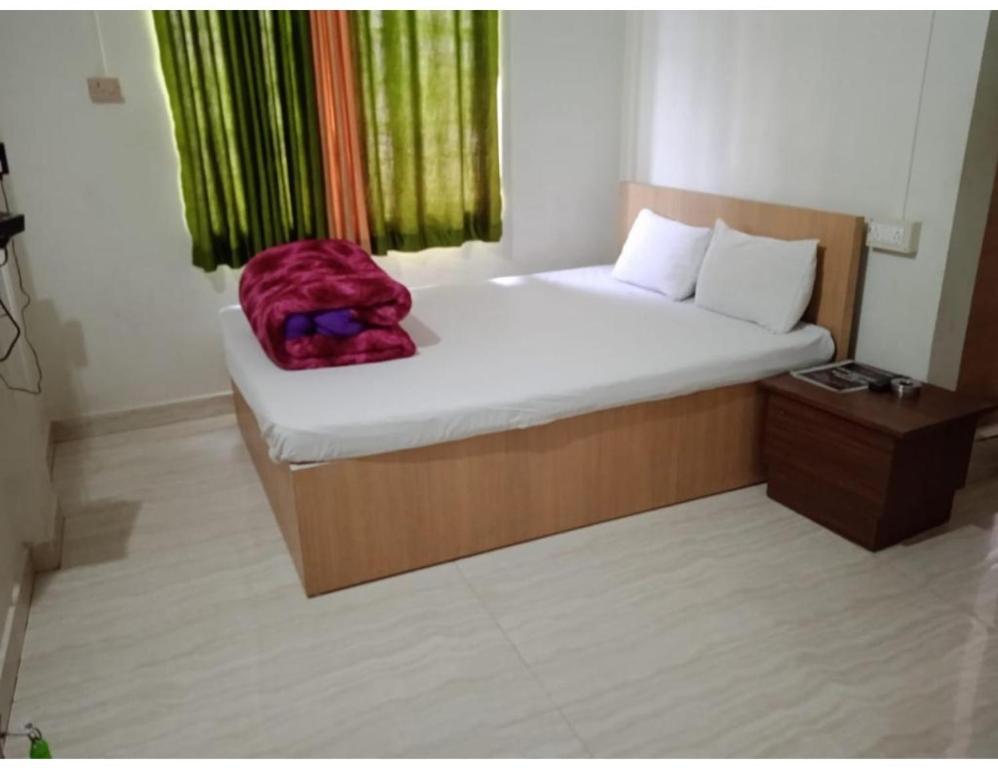 um quarto com uma cama com uma mochila vermelha em Serene Guest House, Pasighat, Arunachal Pradesh em Pasighat