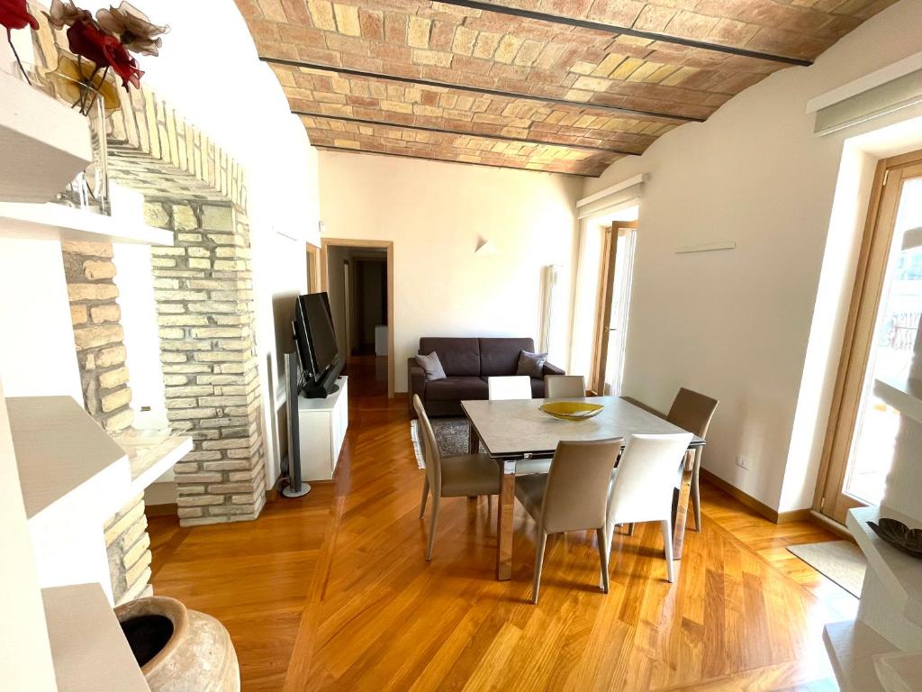 sala de estar con mesa, sillas y sofá en Via Umbria 25 Luxury Suites, en Roma