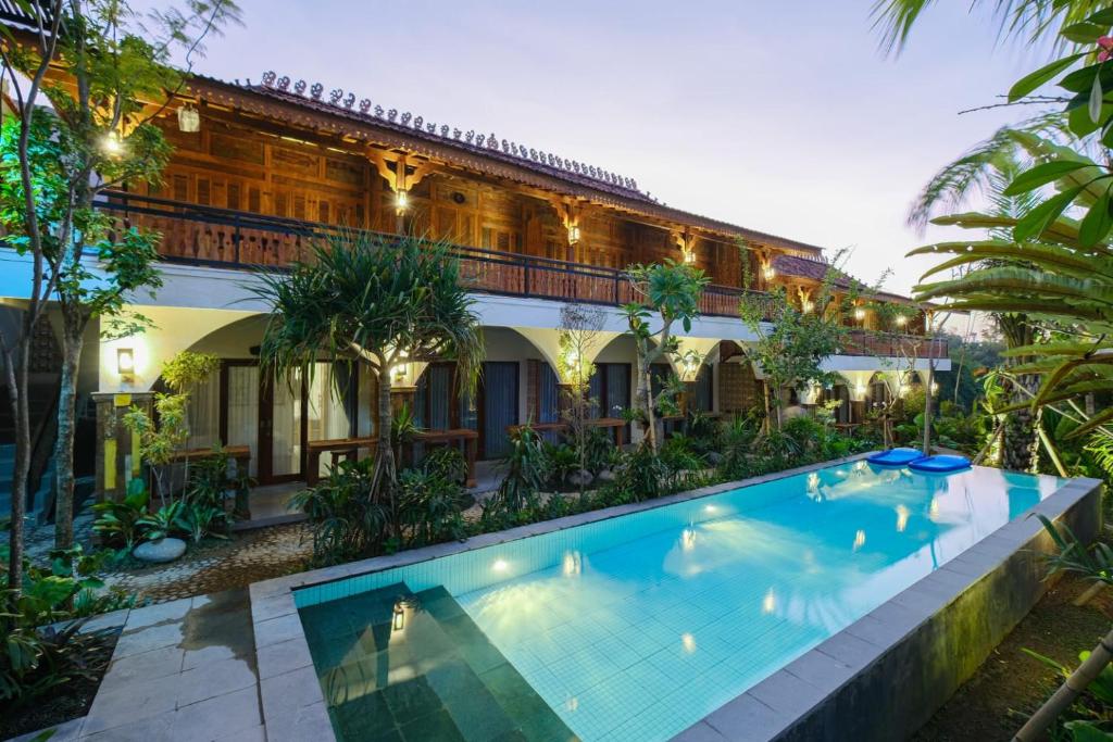 eine Außenansicht eines Hauses mit Pool in der Unterkunft Green Bali Guest House in Munggu