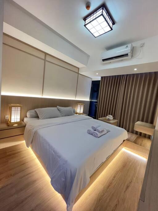 a bedroom with a large white bed in a room at Wawa Guesthouse Pollux Habibie Batam Tower A 17 in Kangboi