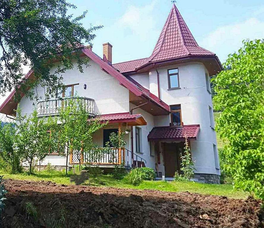 una gran casa blanca con techo rojo en Апартаменти " З ЛЮБОВ'Ю ", en Novyy Kropivnik