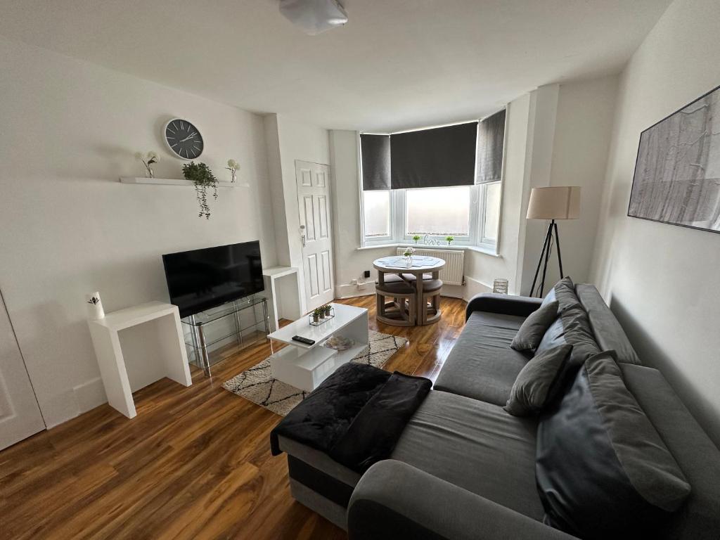 a living room with a couch and a flat screen tv at Cosy Cambridge Centre Flat in Chesterton