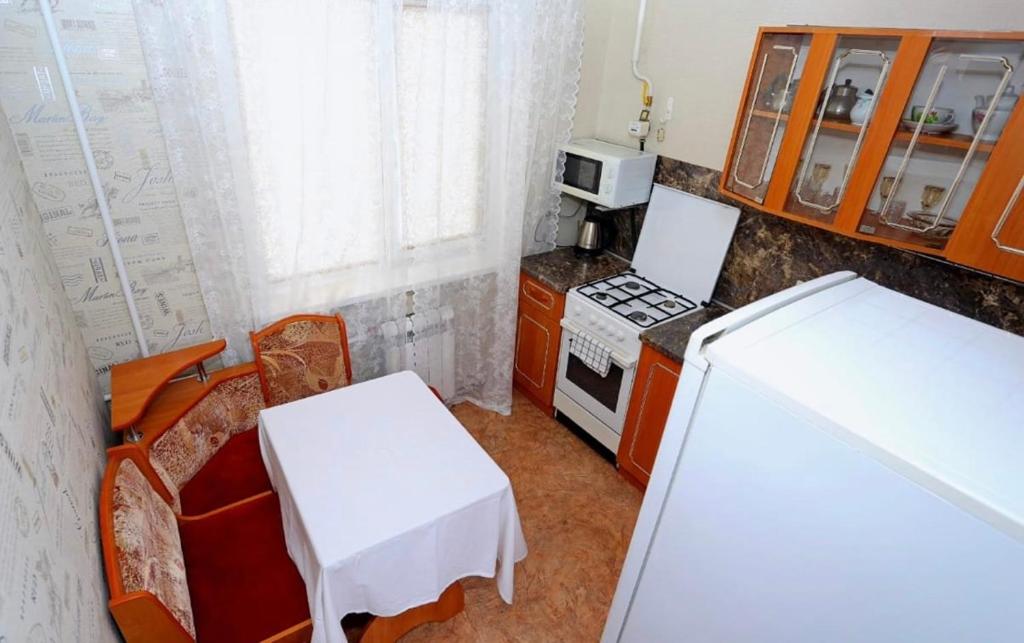 eine kleine Küche mit einem Herd und einem weißen Tisch in der Unterkunft VIP apart 482 in Tbilisi City