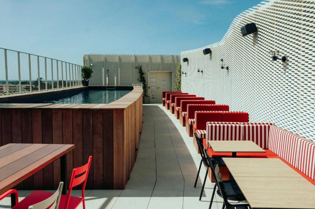 uma varanda com mesas e cadeiras e uma piscina em JOST Auberge de jeunesse Montpellier Centre St Roch em Montpellier