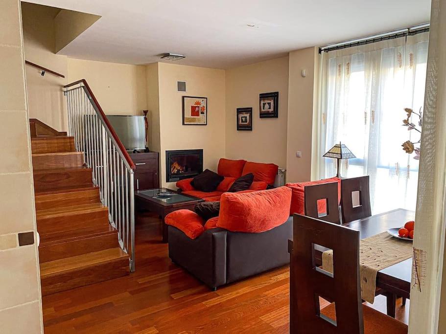 sala de estar con sofá y escalera en Alojamiento ideal en Sabiñánigo, en Sabiñánigo