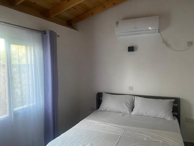 a bedroom with a white bed with a window at Coral Villas Cottage in Ukunda
