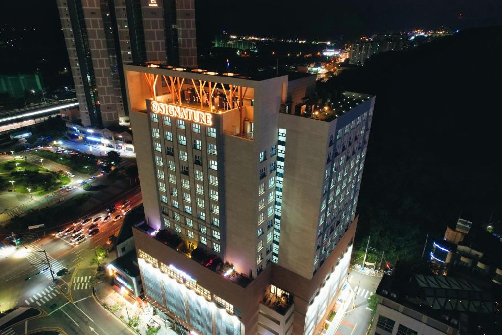 a tall building with a sign on it at night at Jeonju Signature Hotel&Residence in Jeonju