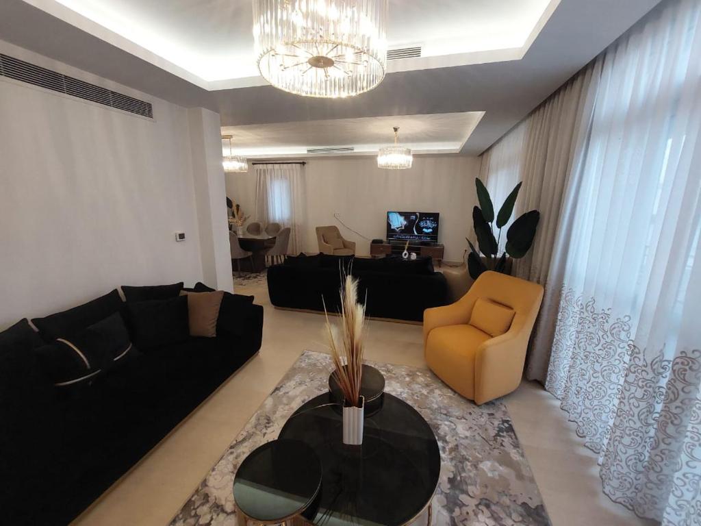 un soggiorno con divano nero e tavolo di CFC, Luxurious 4BR Apartment, Remarkable value unbeatable Location a Il Cairo