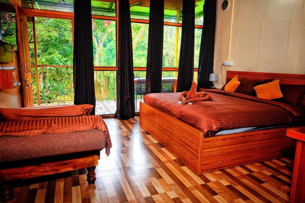 1 dormitorio con cama y ventana grande en Hill Valley Farm House, en Nelliyampathy